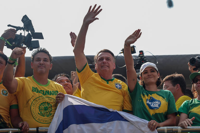 Jair Bolsonaro (PL) acompanhado da esposa Michelle (dir) acenam para multidão durante manifestação, convocada para este domingo (25) na avenida Paulista, em São Paulo.