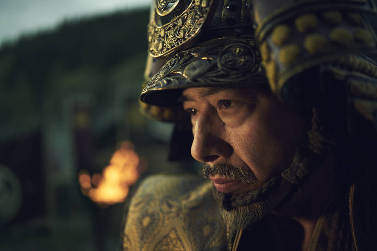 Um homem de meia idade vestindo um capacete e armadura japoneses do século 16 