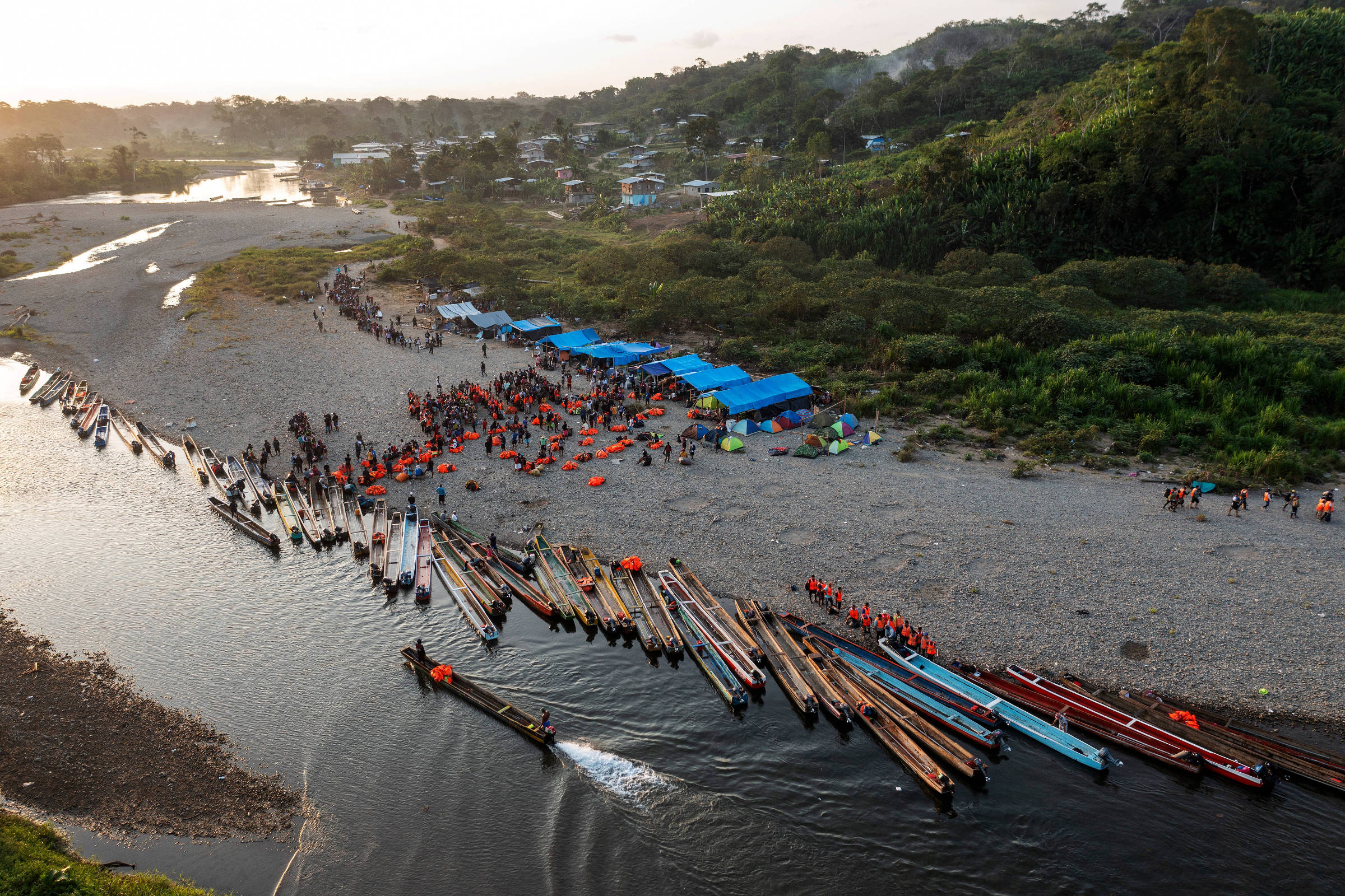 Migrantes fazem fila às margens do rio Tuqueza na comunidade de Bajo Chiquito aguardando para embarcar em canoas