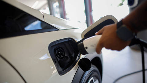 A man demonstrates how to charge a BYD electric vehicle at a BYD dealership in Brasilia, Brazil October 24, 2023. REUTERS/Adriano Machado ORG XMIT: GGGAHM007