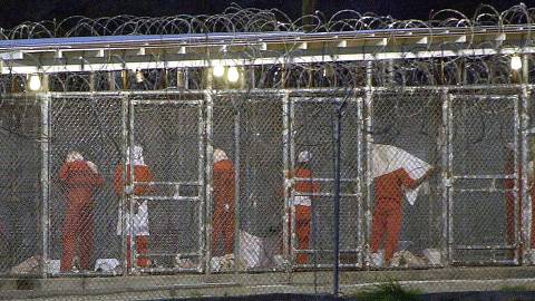 (FILES) In this file photo taken on March 4, 2002, detainees as they prepare themselves for the evening prayer at Camp X-Ray in Guantanamo Bay, Cuba by facing towards Mecca. - Twenty years after the September 11 attacks, the US 