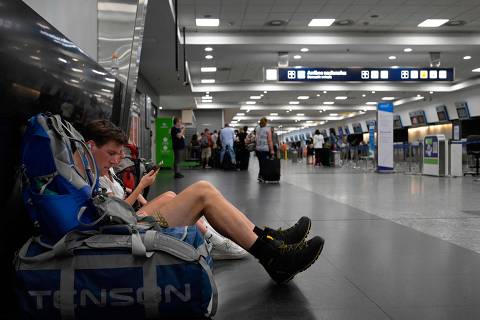 A man sits on the floor next to his luggage during an aeronautical strike at the Jorge Newbery airport in Buenos Aires on February 28, 2024. Hundreds of flights were canceled or rescheduled this Wednesday in Argentina due to a 24-hour strike by aviation unions demanding better salaries, AFP confirmed. (Photo by JUAN MABROMATA / AFP)
