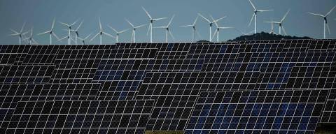 (FILES) This photograph shows photovoltaic solar panels and windmills in the background around the Spanish Navarre town of Milagro on April 5, 2023. Spain generated record 50% of power from renewables in 2023, AFP reports on January 4, 2024. (Photo by ANDER GILLENEA / AFP) ORG XMIT: AG31311.jpg