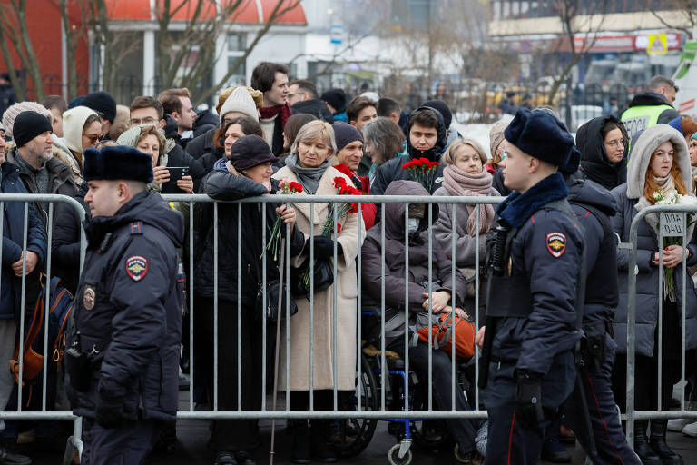 Policiais caminham perto de cidadãos reunidos nos arredores de igreja em Moscou para funeral de Alexei Navalni