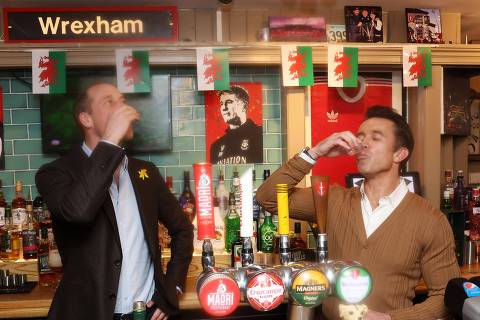 Britain's Prince William, Prince of Wales (L) and co-chairman of Wrexham AFC Rob McElhenney (R) take a drink behind the bar during a visit to the The Turf Pub, near Wrexham AFC as he marks St. David's Day on March 1, 2024 in Wrexham, north Wales. (Photo by Chris Jackson / POOL / AFP) ORG XMIT: 776113850