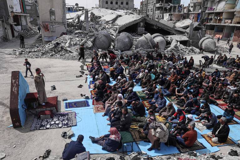 Palestinos fazem oração em frente às ruínas da mesquita Al-Faruq, na cidade de Rafah