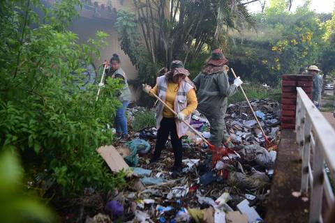 Municipal workers collects scattered garbage in a neighbourhood of Asuncion, during an operation aimed at erradicating the Aedes aegypti mosquito --which transmits Dengue fever and Chikungunya-- on January 26, 2024. Hospitals in Asuncion are receiving many patients with dengue symptoms. The mosquito-borne disease, endemic to tropical areas, causes high fevers, headaches, nausea, vomiting, muscle pain and, in the most serious cases, bleeding that can lead to death.. (Photo by NORBERTO DUARTE / AFP) ORG XMIT: 1621