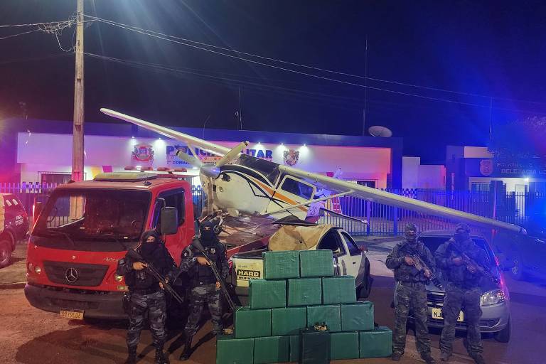 Policiais militares de Mato Grosso junto a avião, veículos e drogas apreendidas durante operação em Sapezal. 