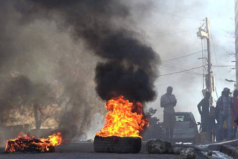 This screen grab taken from AFPTV shows tires on fire near the main prison of Port-au-Prince, Haiti, on March 3, 2024, after a breakout by several thousand inmates. At least a dozen people died as gang members attacked the main prison in Haiti's capital, triggering a breakout by several thousand inmates, an AFP reporter and an NGO said on March 3. 