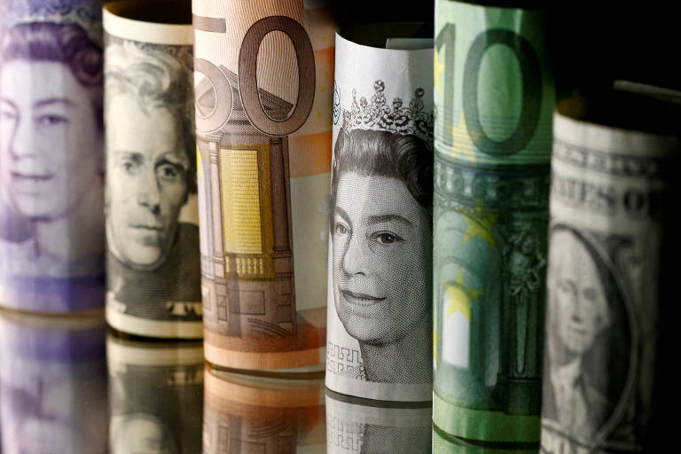 Notas enroladas de dólar, euro e libra esterlina