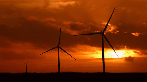The sun sets behind power-generating windmill turbines near Waremme, Belgium January 24, 2024. REUTERS/Yves Herman ORG XMIT: PPPYH02