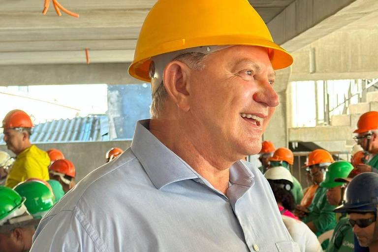 Antônio Ramalho sorri ao lado de pedreiros em construção
