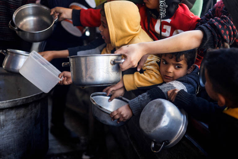Crianças palestinas em fila para receber comida em Rafah, no sul da Faixa de Gaza