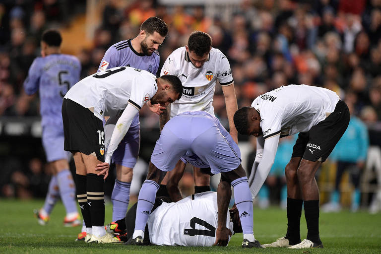 Diakhaby, do Valencia, caído no gramado do Mestalla após choque contra Tchouaméni, do Real Madrid