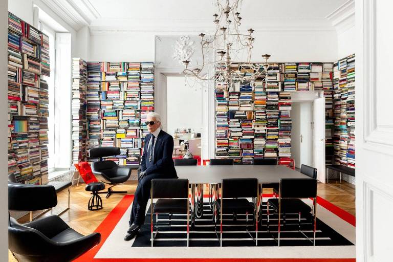 O estilista Karl Lagerfeld, morto em 2019, em seu antigo apartamento, em Paris, em biblioteca cheia de livros