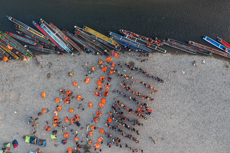 Migrantes fazem fila às margens do rio Tuqueza, no Panamá