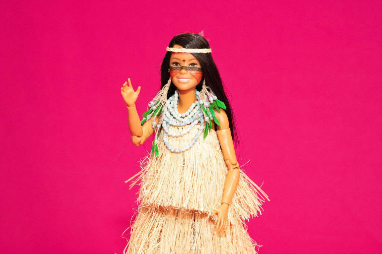 Imagem mostra Barbie indígena sobre um fundo rosa