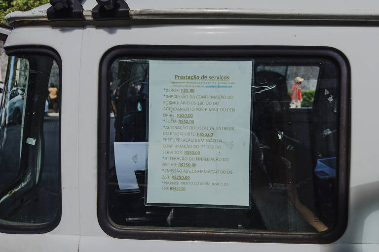 Tabela de preços da kombi-gráfica que oferece serviços de impressão e de auxílio ao solicitante de visto em frente ao Casv, na Vila Mariana