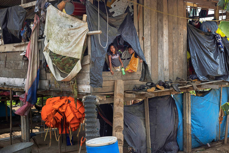 Crianças indígenas observam de sua casa o movimento de migrantes na comunidade indígena de Bajo Chiquito