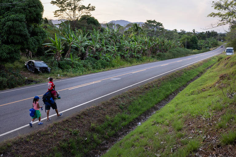 Família venezuelana caminha às margens da rodovia Panamericana, no Panamá