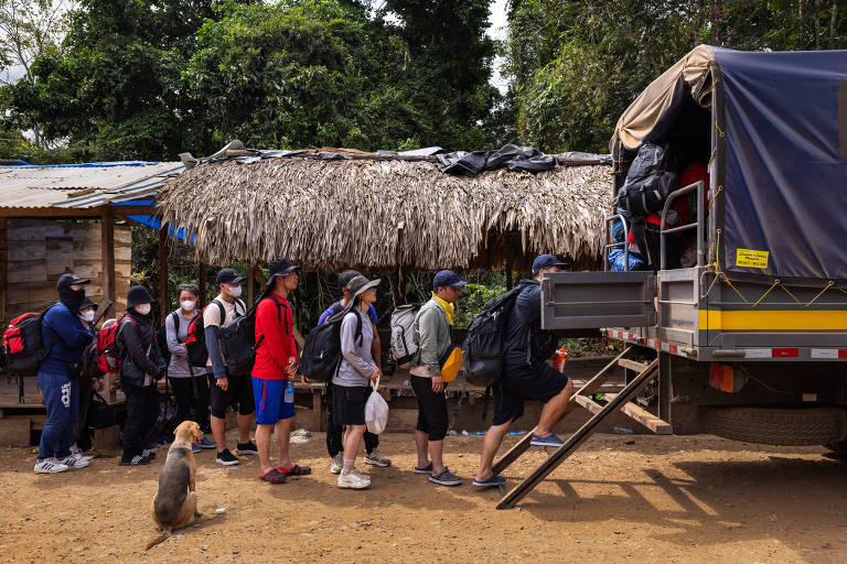 Imigrantes chineses embarcam em caminhão do Serviço Nacional de Migrações do Panamá em Puerto Limón para serem conduzidos até a Estação de Recepção Migratória de San Vicente