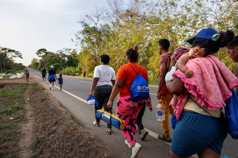 Sem dinheiro para avançar até a Costa Rica, imigrantes da Venezuela que já haviam chegado ao Panamá caminham pela rodovia Panamericana em busca de lugar para sacar ou obter dinheiro
