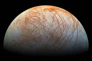 JupiterÕs moon Europa, whose yellowish streaks contain sodium chloride. (NASA/JPL/Galileo via The New York Times)