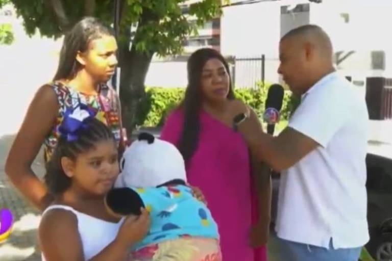 Em foto colorida, família é entrevistada por emissora de  TV