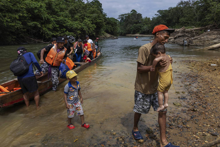 Imigrantes desembarcam de pirágua (canoa) ao chegar à Estação de Recepção Migratória de Lajas Blancas, na Comarca Emberá, no Panamá, após cruzar a selva de Darién