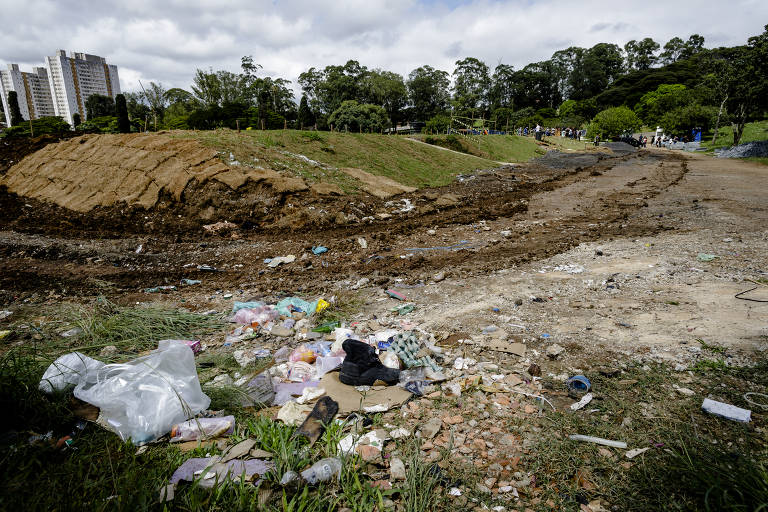 Cemitério Vila Carmosina, em Itaquera, na zona leste, tem copos e garrafas plásticas com água parada em meio ao mato alto rente ao muro externo