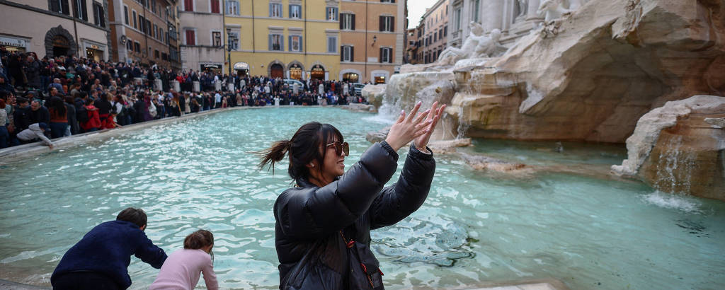 Yuting, da China, joga duas moedas na Fontana de Trevi em Roma, Itália, em 16 de fevereiro de 2024