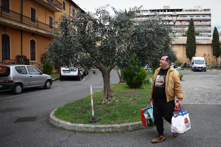 Luigi, 55 anos, que antes de perder o emprego era construtor e dono de uma empresa de sistemas de videovigilância, sai depois de fazer compras no Caritas Emporium, um supermercado financiado com dinheiro arrecadado na Fontana de Trevi, em Roma, Itália, 27 de fevereiro de 2024