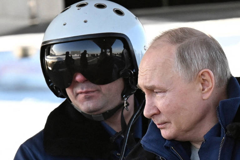 Putin ao lado de um homem com um capacete