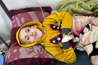 Palestinian boy Yazan Al-Kafarna lies on a bed, in Rafah in the southern Gaza Strip