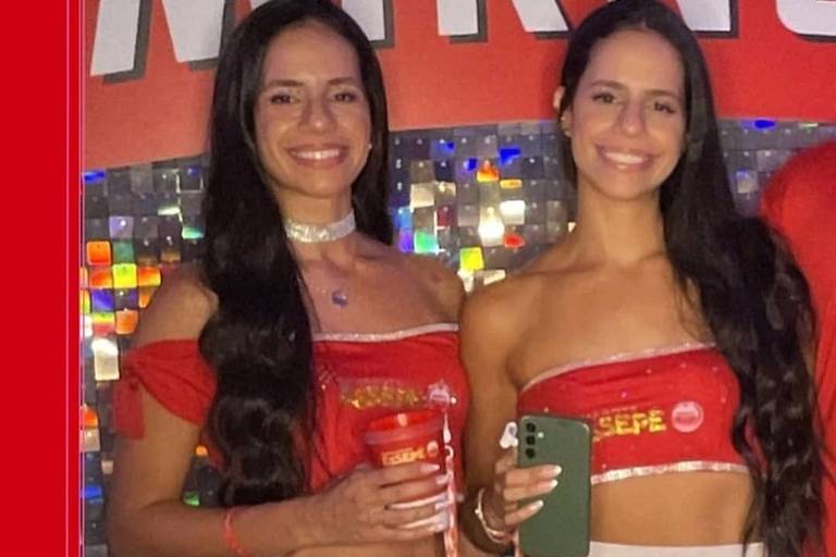 Irmãs Fernanda e Vanessa Furino, durante o Carnaval, na capital paulista. As duas vestem saia prateada, top vermelho e têm longos cabelos pretos