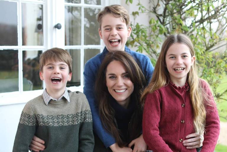 Em uma varanda, Kate posa para foto rodeada por seus filhos