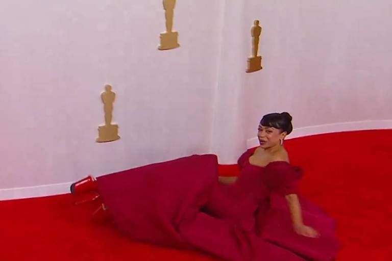 Em foto colorida,mulher leva tombo no tapete vermelho de uma premiação