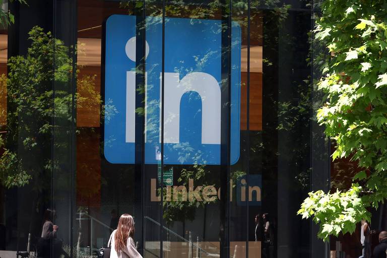 pedestre passa por uma placa em um escritório do LinkedIn