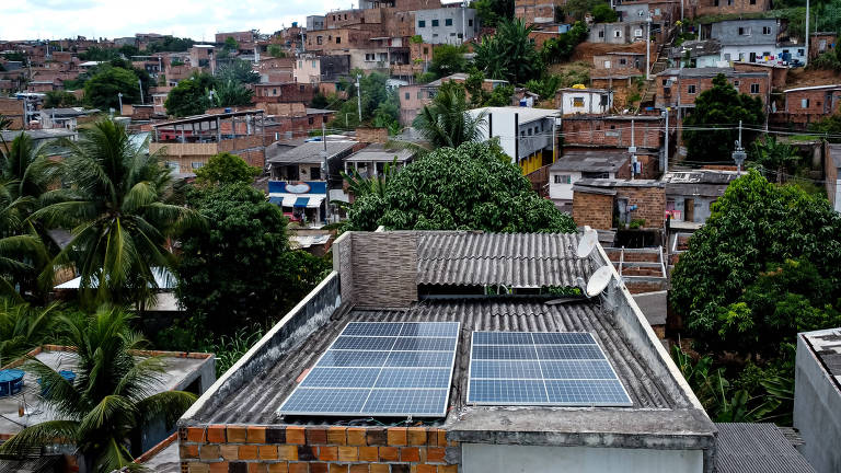 placa solar no teto de casa sem reboco com casas ao redor na periferia de salvador