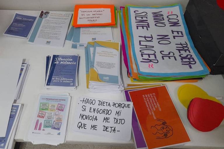 Cartazes e folhetos sobre contracepção e violência doméstica sobre uma mesa