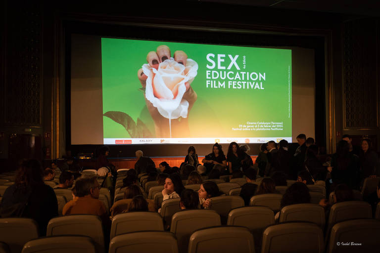 Sala de cinema em que na tela está escrito "Sex Education Film Festival"