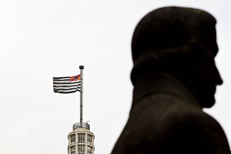 Vista da bandeira de São Paulo sob o antigo edifício Banespa (atual Santander), desde a estátua de Jose Bonifácio, na Praça do Patriarca, região central