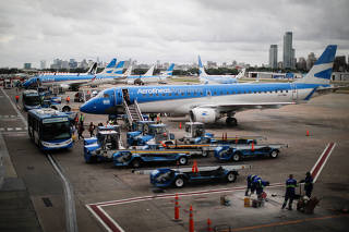 Passengers descend from an Aerolineas Argentinas Embraer 190 aircraft, at the Aeroparque Jorge Newbery airport