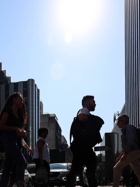 Paulistanos caminham sob o sol intenso na avenida Paulista, na região central de São Paulo; nova onda de calor eleva a temperatura nos próximos dias no estado