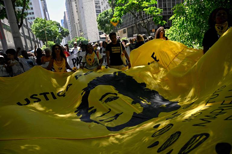 Manifestantes carregam grande faixa com o rosto de Marielle Franco e os dizeres: Justiça por Marielle