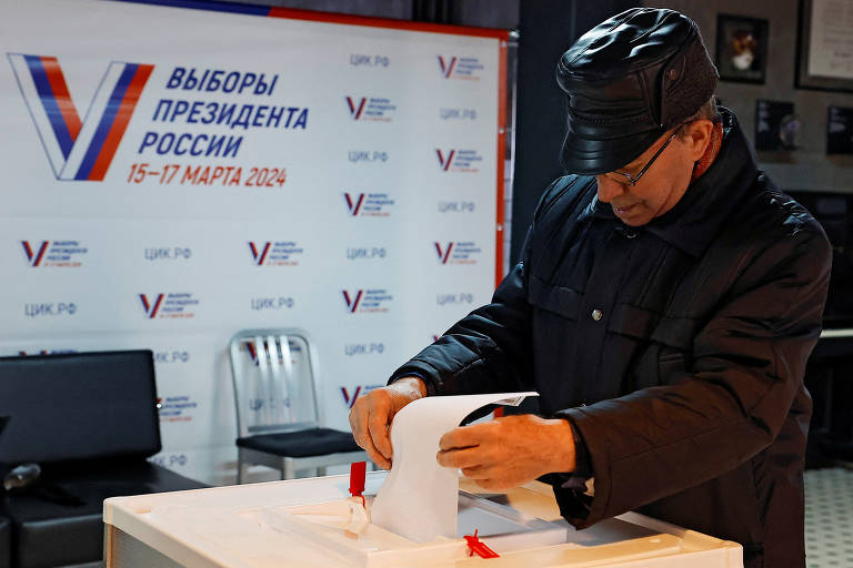 Homem deposita seu voto em seção eleitoral de Moscou durante pleito presidencial da Rússia
