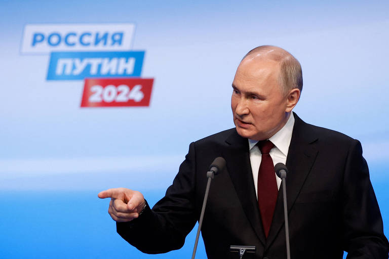 O presidente russo responde a jornalistas após a vitória na eleição coma logomarca de sua campanha, que diz "Rússia - Putin - 2024", às suas costas