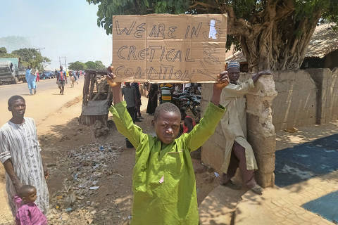 A boy holds a sign to protest against, what a teacher, local councilor and parents said, the kidnapping of hundreds school pupils by gunmen after the Friday prayer, in Kaduna, Nigeria March 8, 2024. REUTERS/Stringer ORG XMIT: PPPNGA02