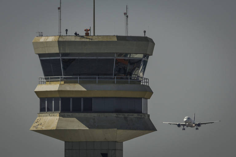Avião se aproxima do aeroporto de Congonhas, na zona sul de São Paulo; à frente, torre de comando do terminal