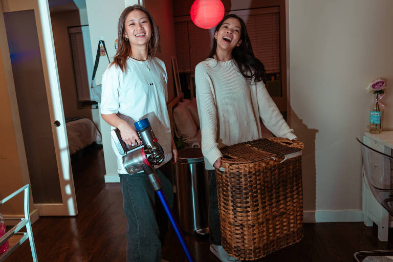 Ellicia Chiu, à esquerda, com Cher Su, à direita, posam para a fotografia  com seu aspirador de pó de US$ 135 e cesto duplo de roupa suja de US$ 20 